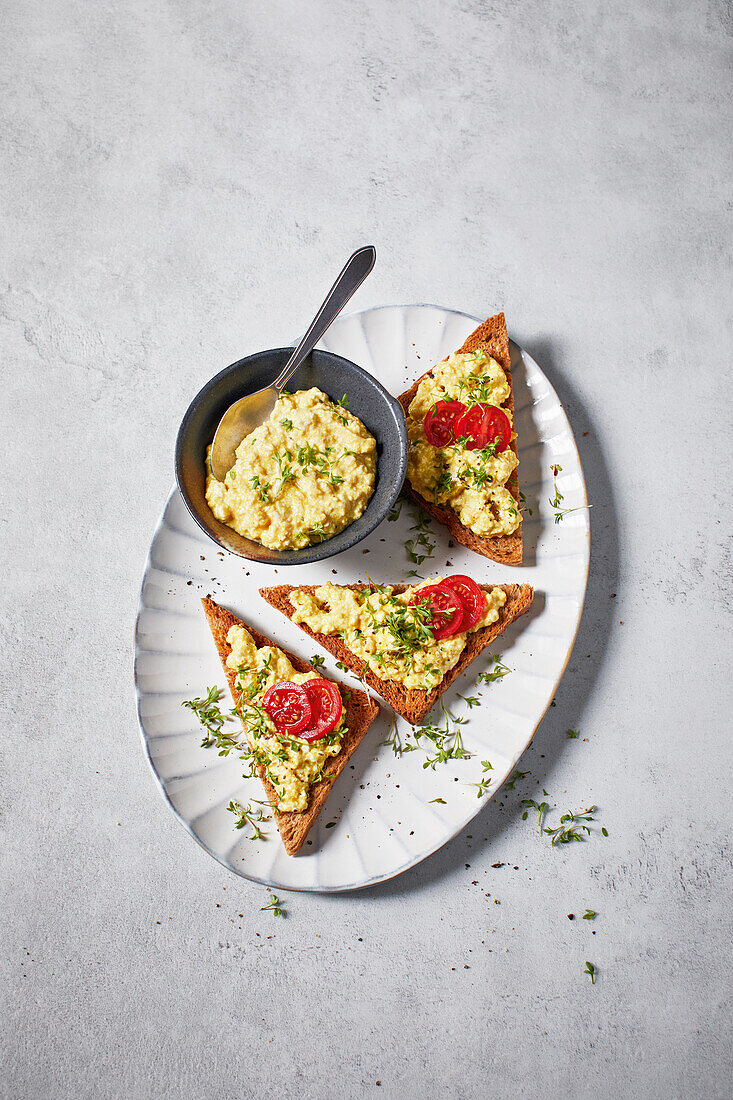 Veganer Eiersalat auf Toast mit Tomaten und Kresse