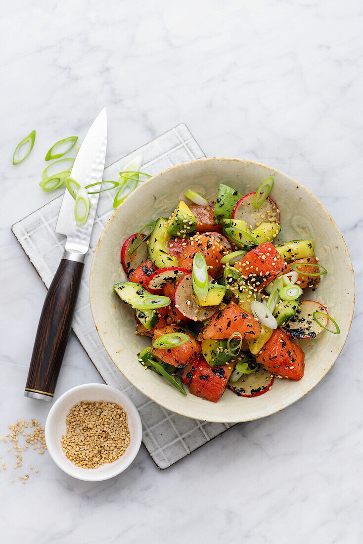 Cucumber and watermelon salad with sesame seeds and spring onions