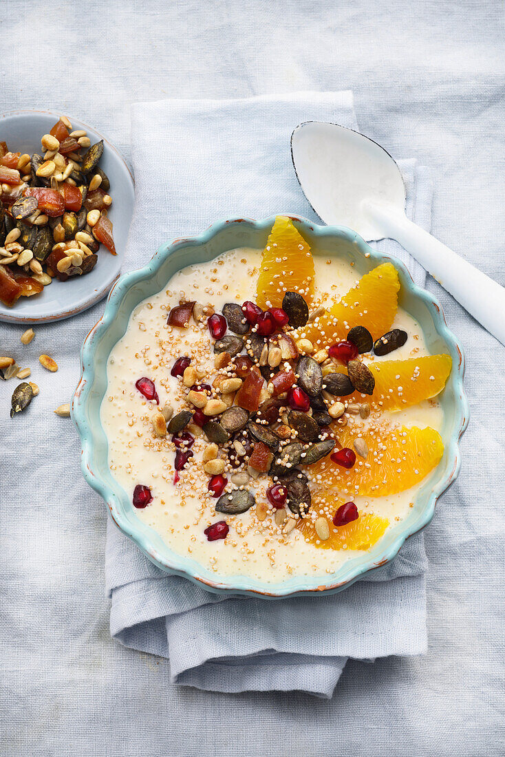 Smoothie bowl with oranges, nuts and pomegranate seeds