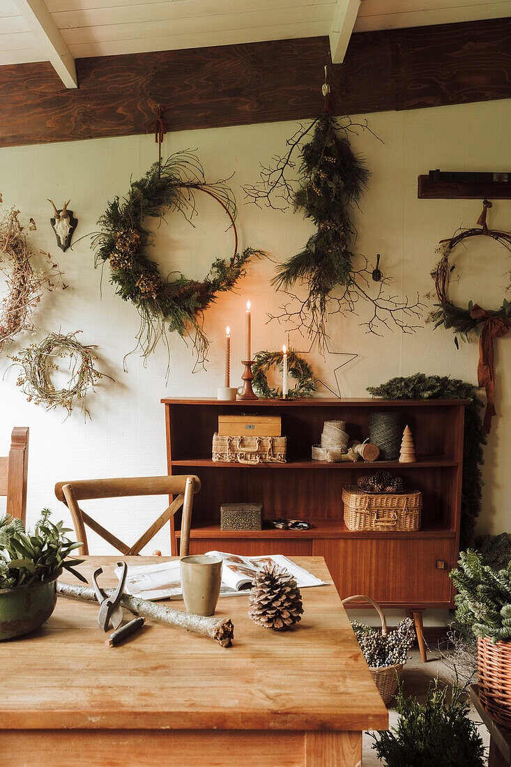 Creative craft room with natural wreaths and vintage wooden shelf