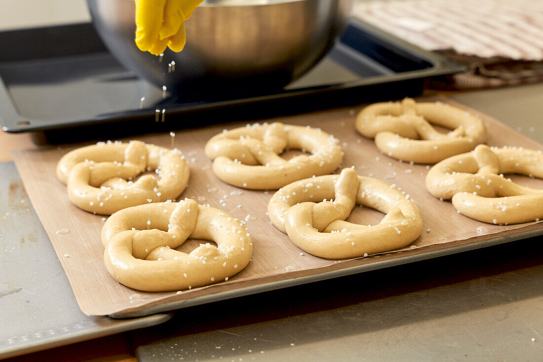 Sprinkle pretzel dough pieces with salt before baking