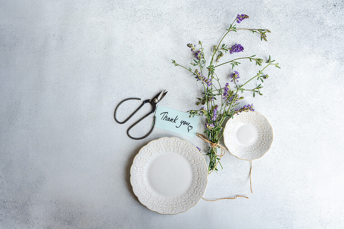 Summer table setting with meadow flowers and ceramic crockery