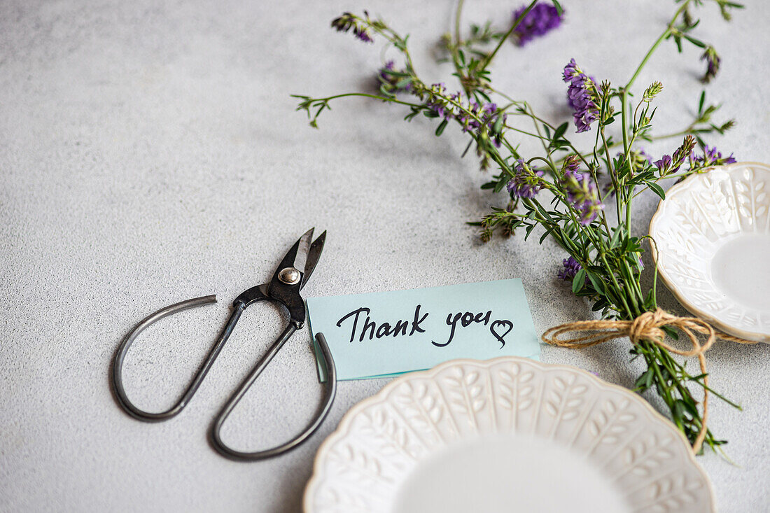 Summer table setting with field flowers and ceramic plates