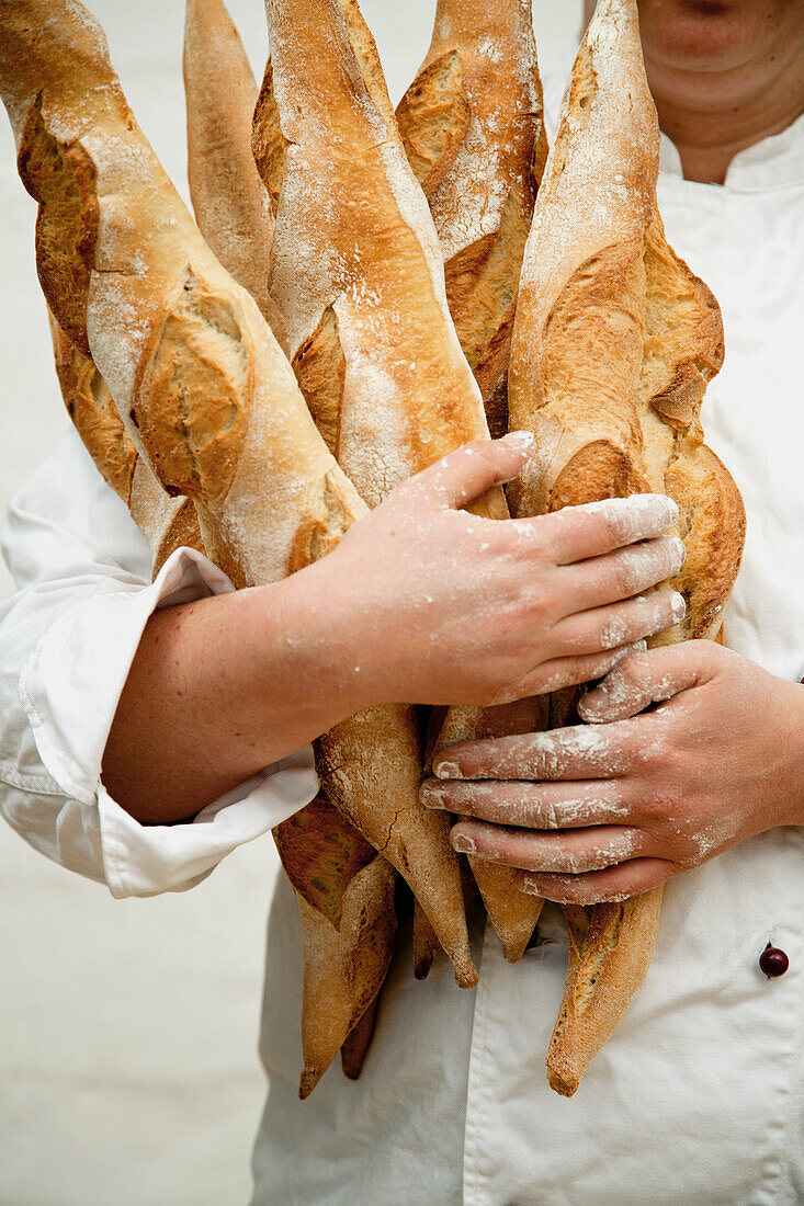 Bäcker hält frische Baguettes