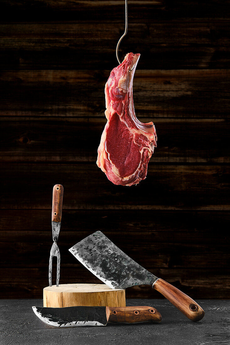 Tomahawk-Steak am Haken und handgeschmiedetes Metzgerset