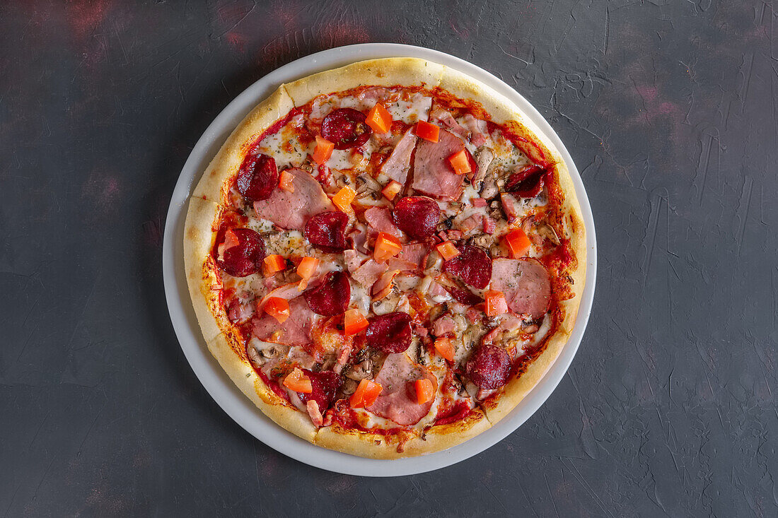 Pizza with ham, salami and mushrooms