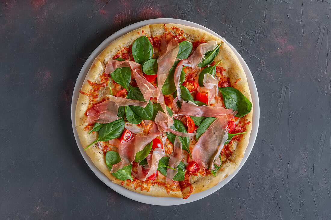 Pizza mit Rohschinken, Spinat und Champignons