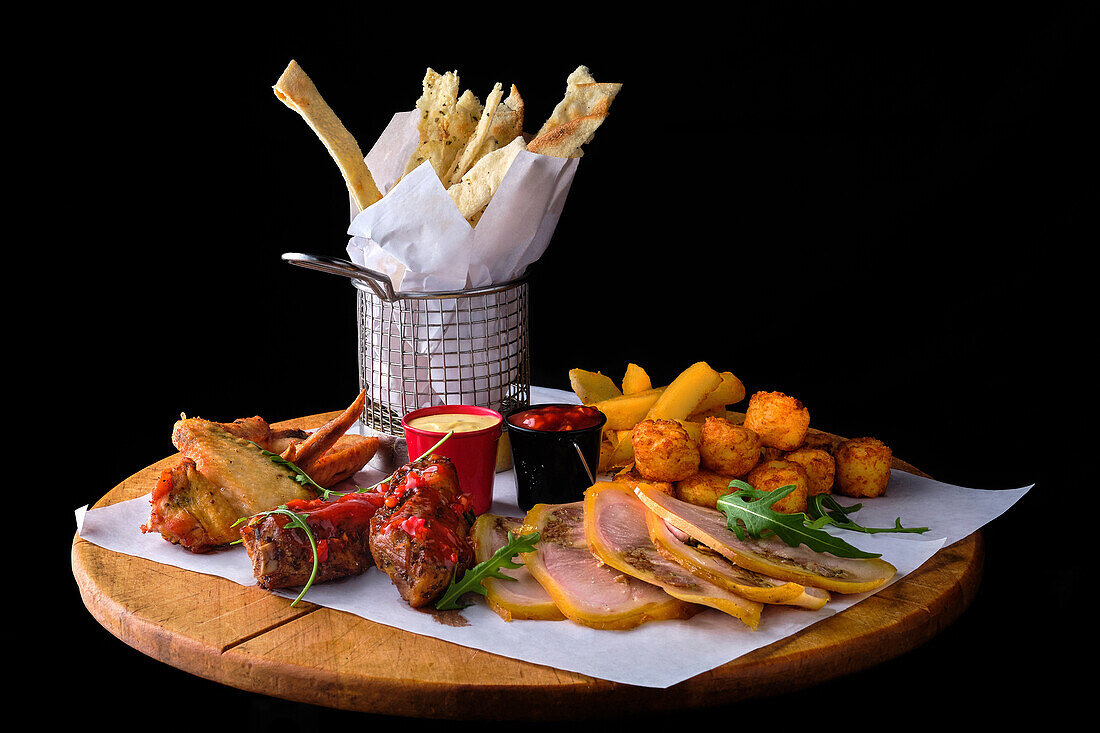 Mixed beer snacks with sauces and bread sticks