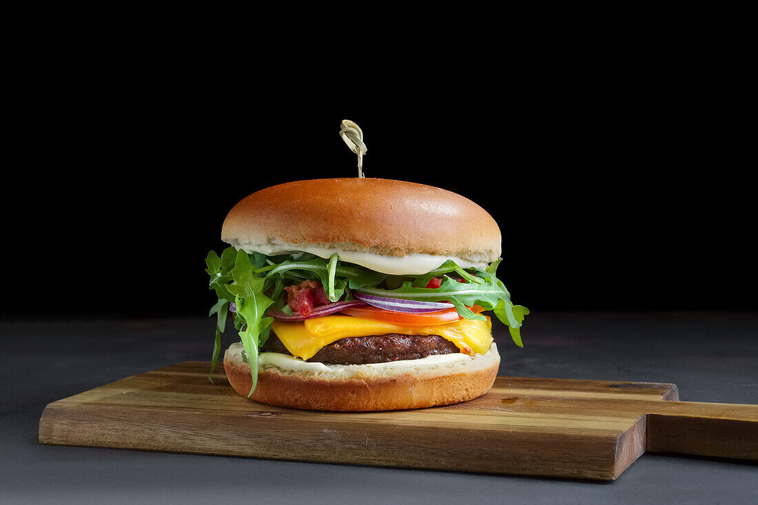 Cheeseburger mit Salat, Käse und Zwiebeln