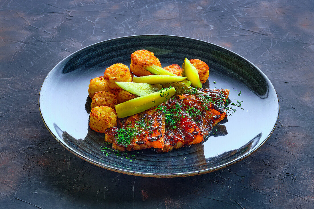 Gegrillte Rippchen mit Kartoffelbällchen und Essiggurke