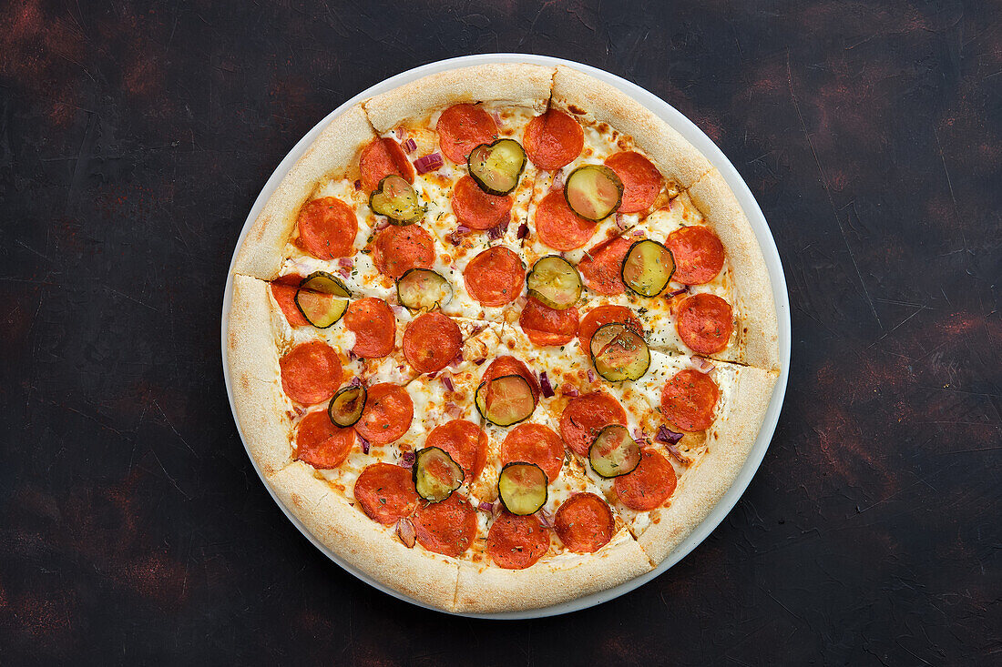 Pizza with pepperoni and pickled gherkins