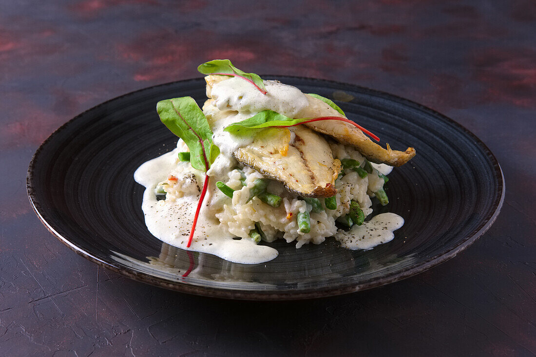 Fried fish fillet on rice with green beans and chard