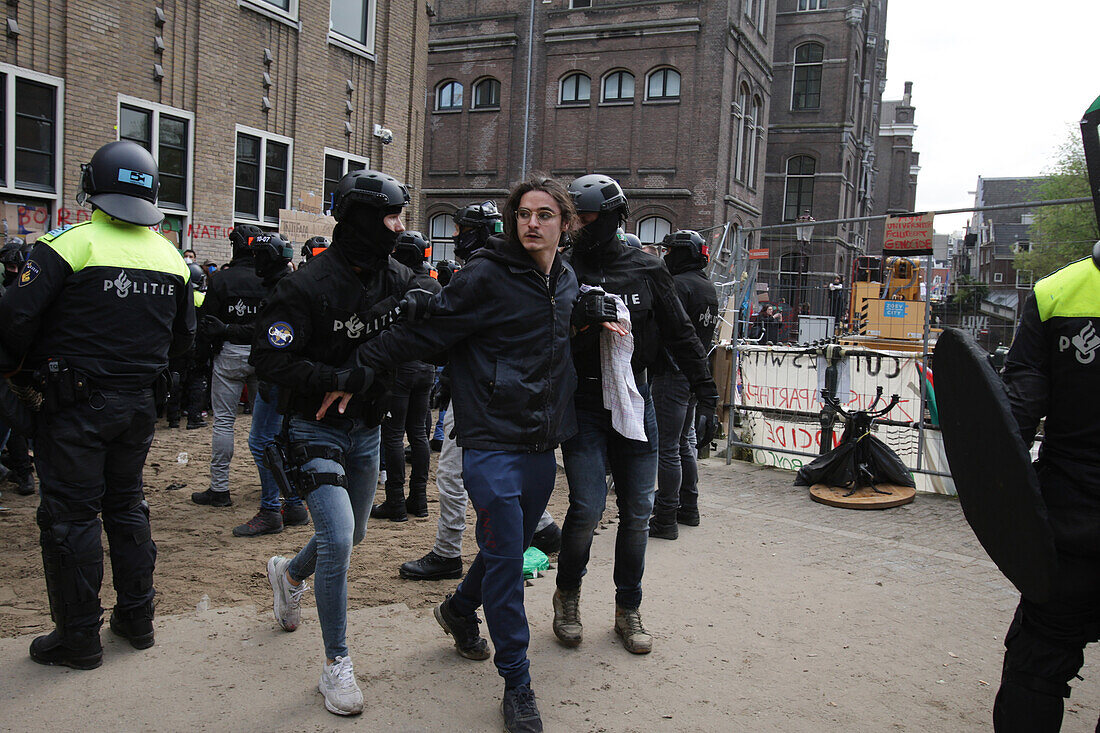 Niederländische Anti-Riot-Polizei durchbricht Barrikaden, die von pro-palästinensischen Studenten errichtet wurden, die gegen den anhaltenden Konflikt zwischen Israel und den Palästinensern an der Universität von Amsterdam protestieren, am 8. Mai 2023 in Amsterdam, Niederlande.