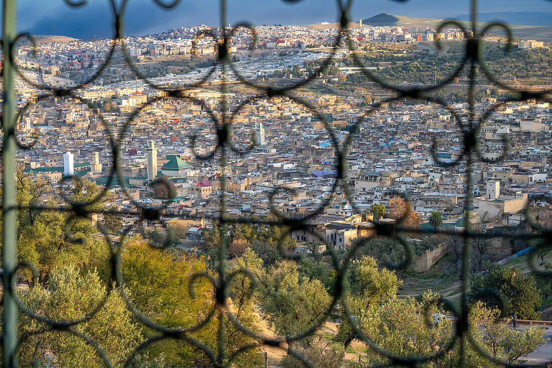 Die Weite der Medina von Fez durch ein verziertes Gitter betrachtet.