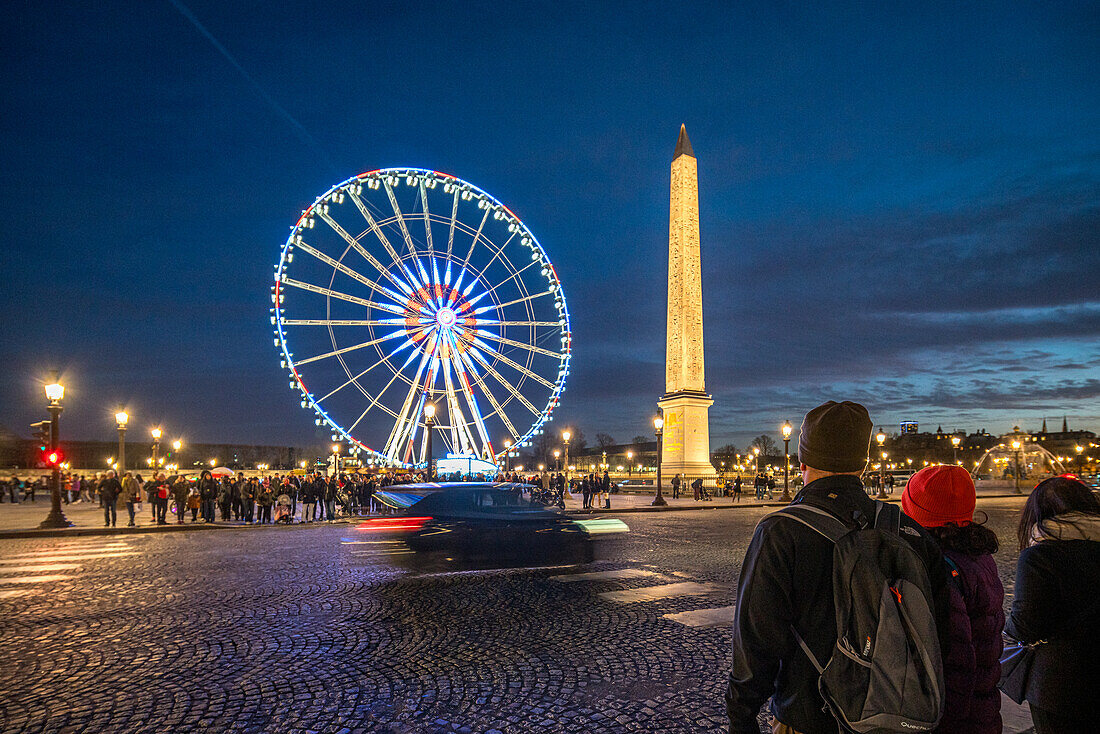 Ein Riesenrad erhellt den Abend vor dem berühmten Obelisken.