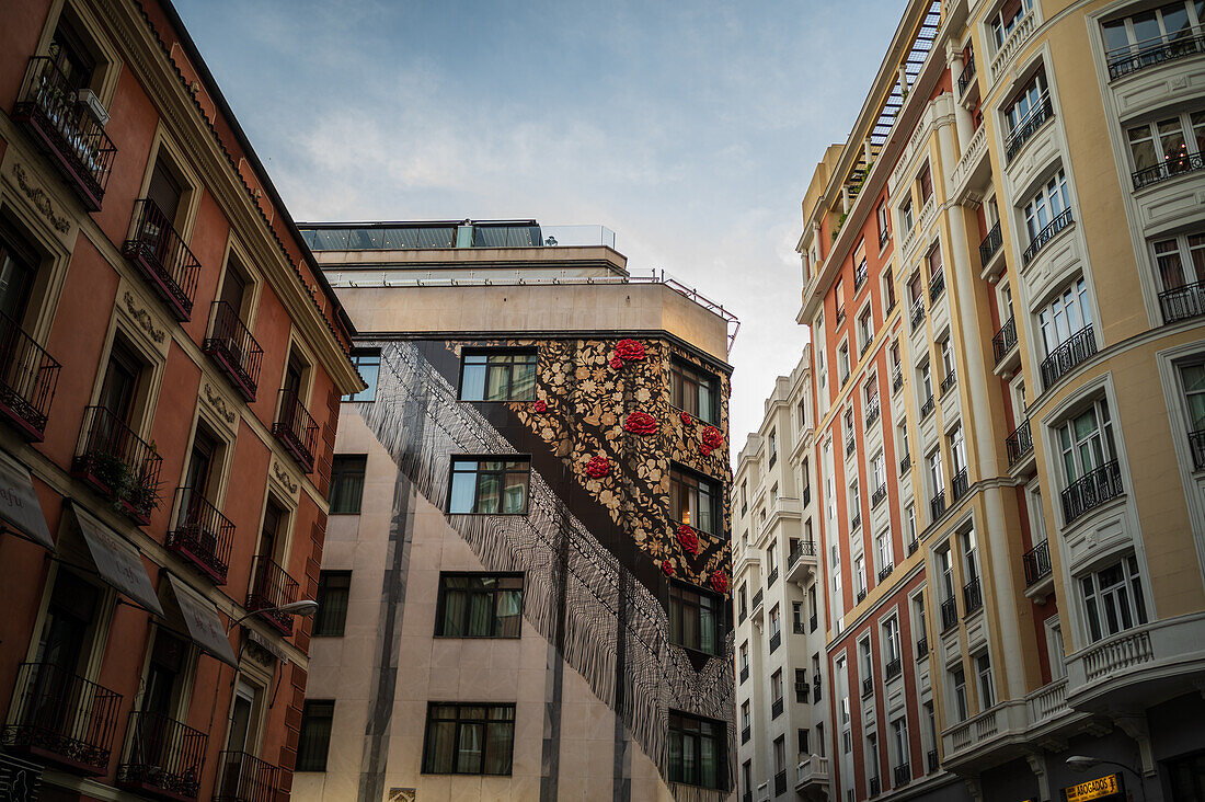 Art mural of a traditional chulapa scarf in a building facade during San Isidro festivities, Madrid, Spain