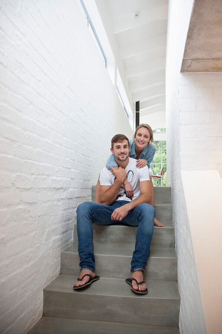 Smiling Young Couple Sitting on Stairs