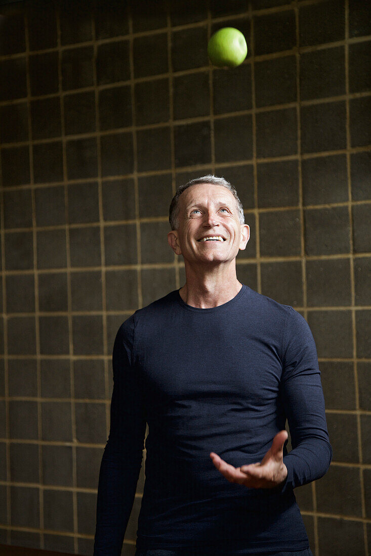 Mature Man Throwing an Apple