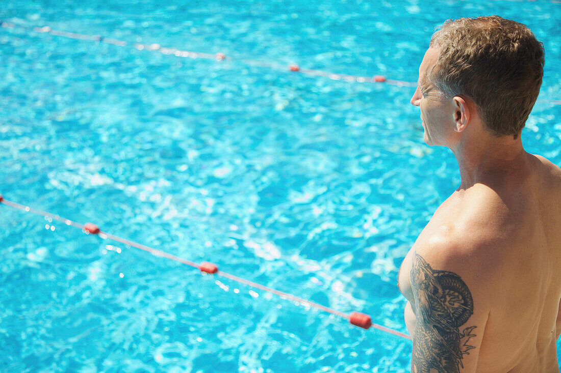 Mature Man Standing by Swimming Pool