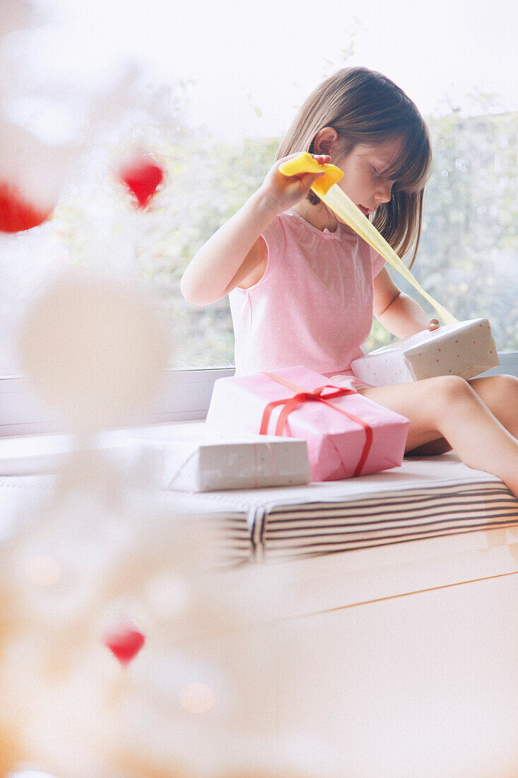 Young Girl Unwrapping Christmas Present