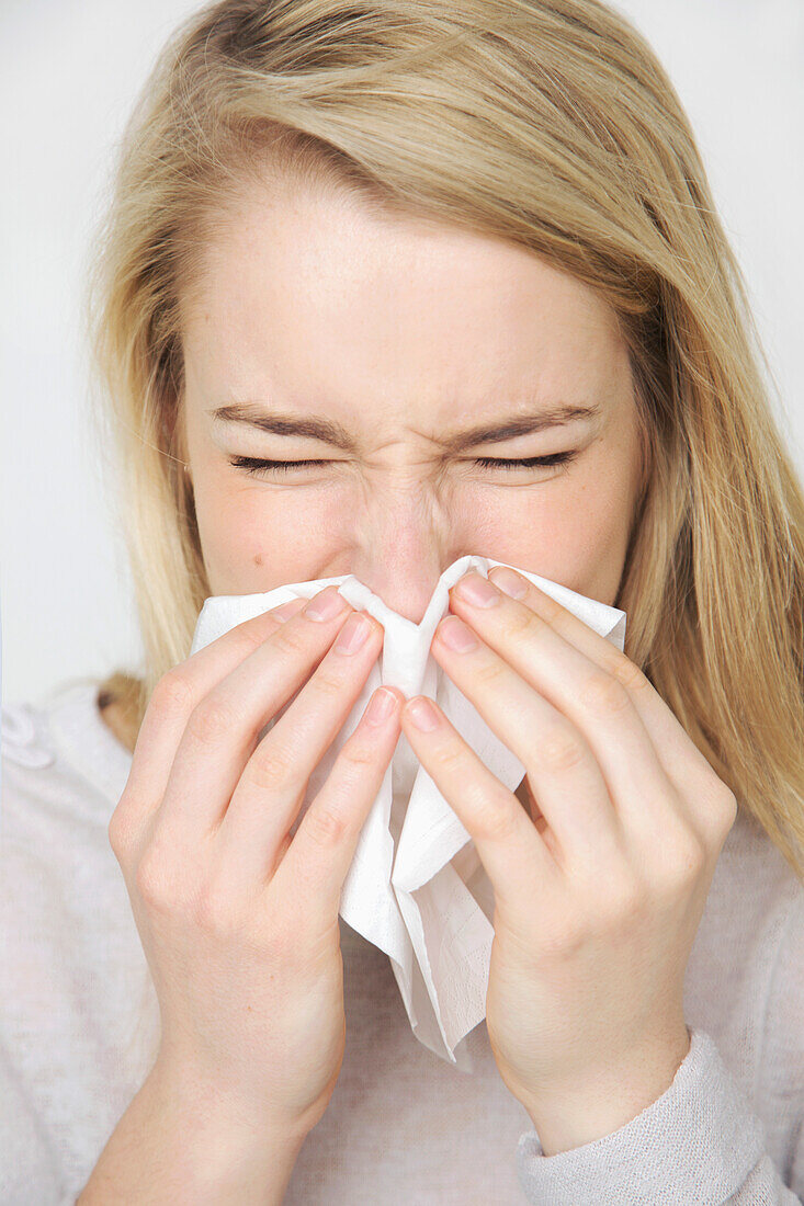 Young Woman Blowing her Nose Sneezing