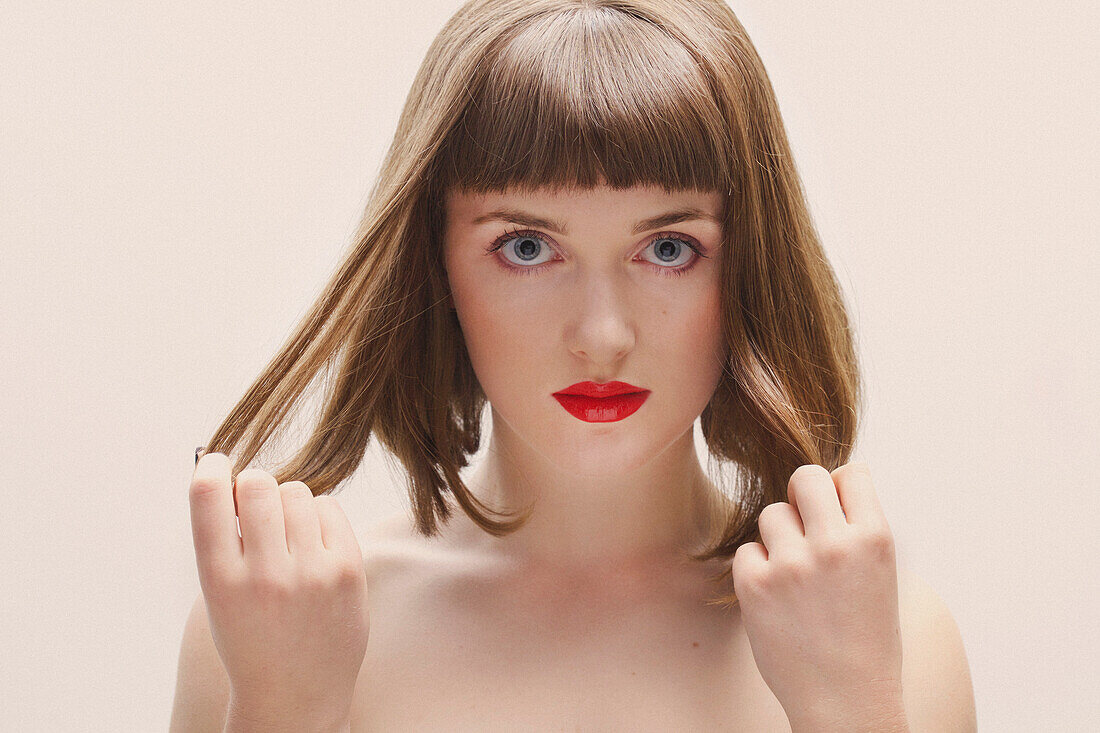 Close up of Young Woman with Red Lips Touching her Hair