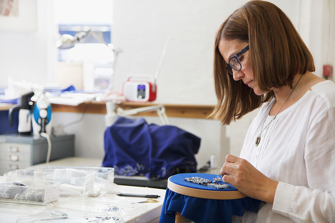 Frau bei der Arbeit im Stickereistudio