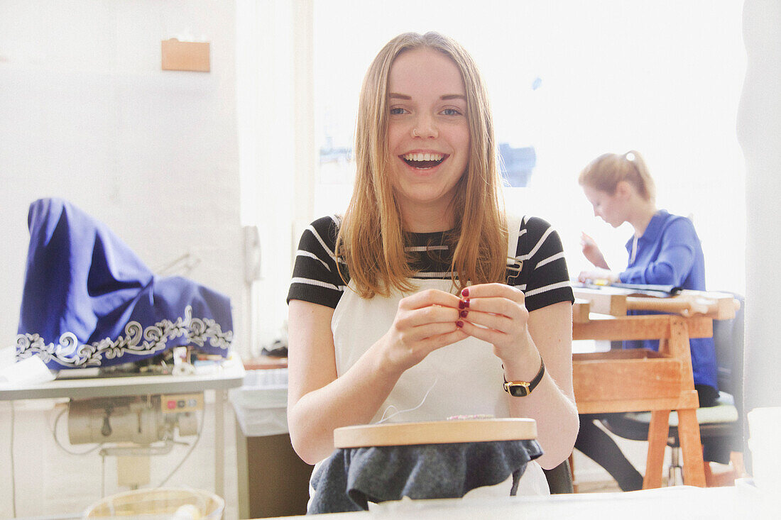 Smiling Female Employee at Embroidery Design Studio