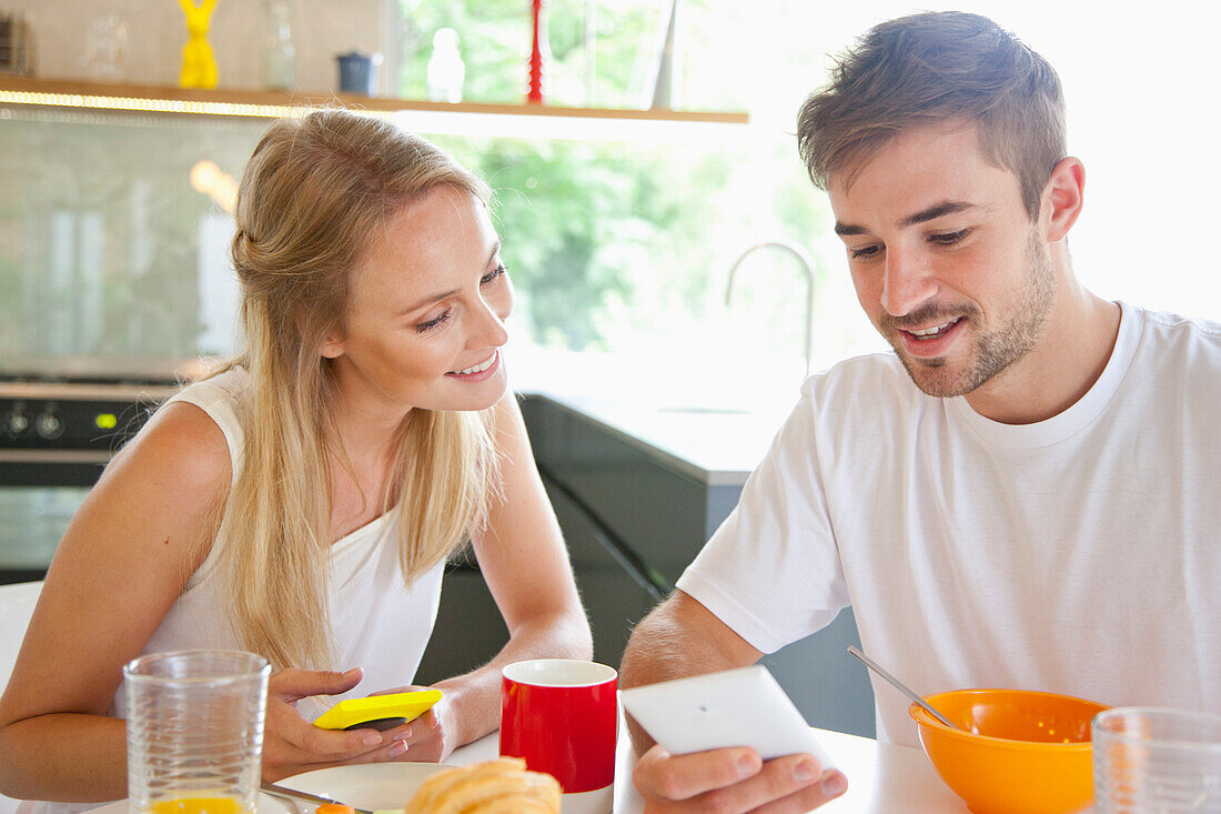 Pärchen beim Frühstück mit Smartphone