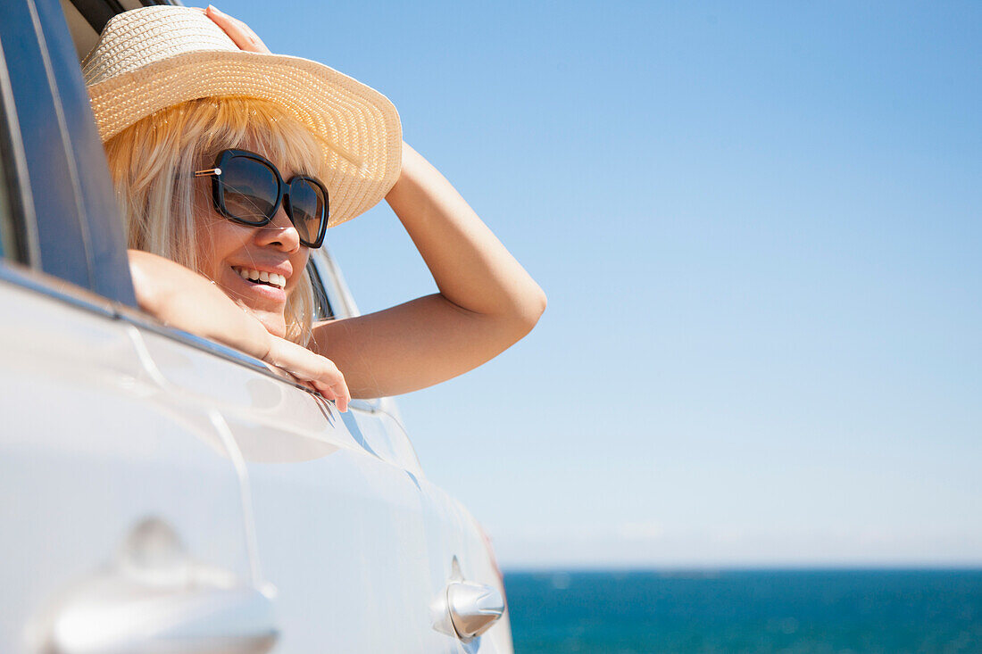 Woman Looking out of Car Window, Ocean in Background