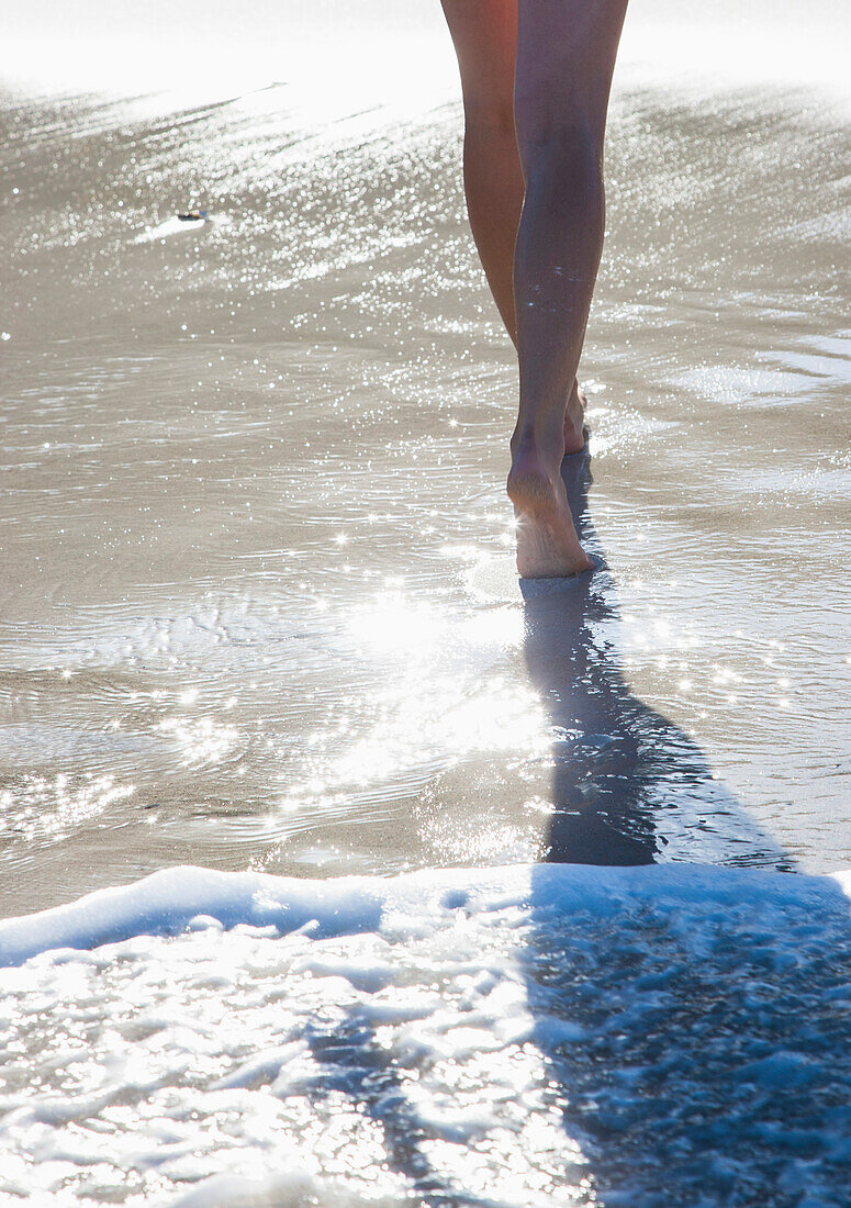 Frau, die am Strand im Meerwasser spazieren geht, tiefer Ausschnitt