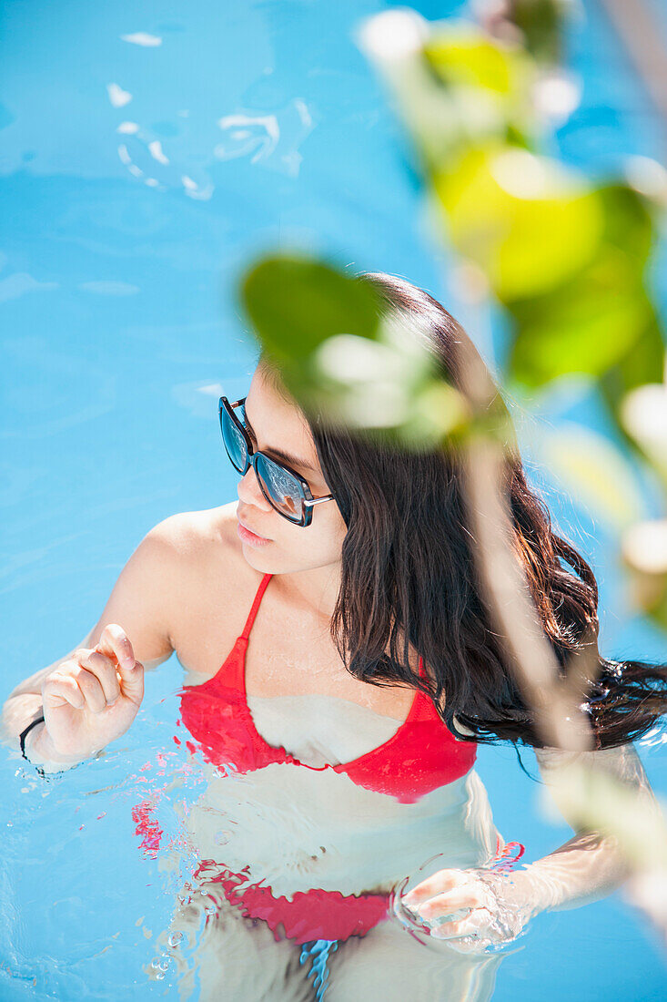 Woman in Swimming Pool with Leaves in foreground