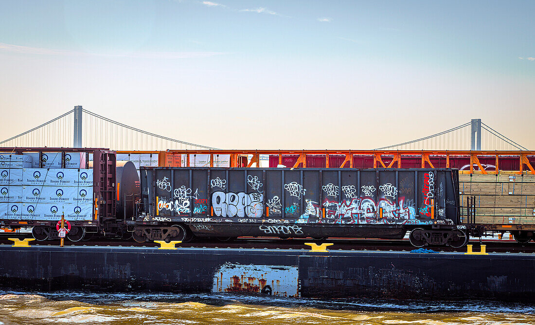 Railroad car and freight on barge, New York Bay with Verrazzano-Narrows Bridge in background, New York City, New York, USA