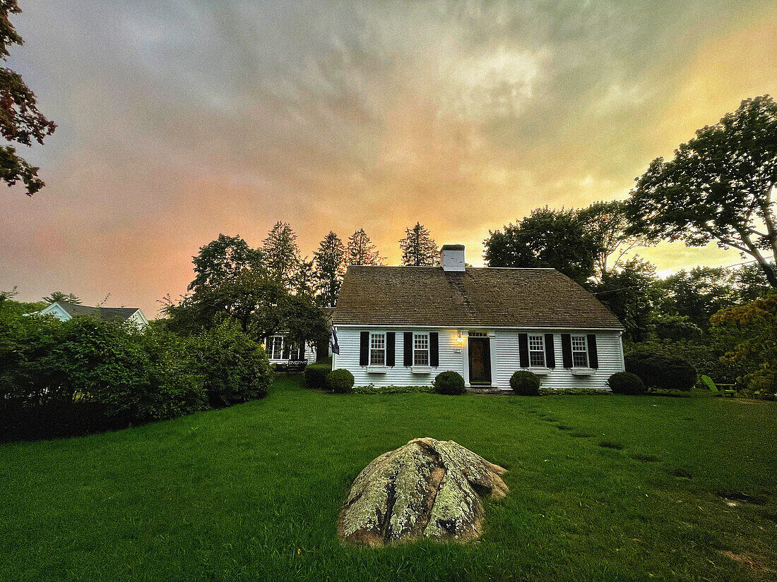 Bow roof cape house at sunset with dramatic sky