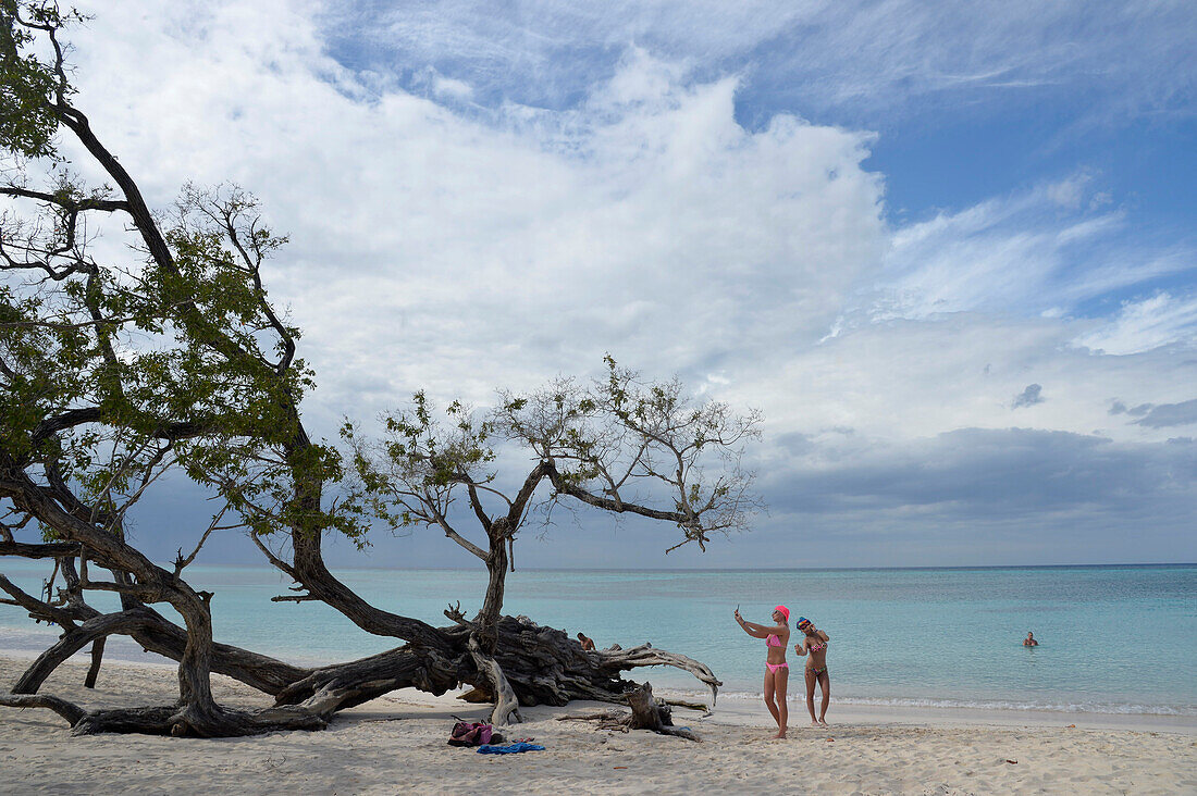 Cuba,Holguin,Guardalavaca beach,2 tourists in swimming suits are posing for selfies in front of the turquoise blue sea