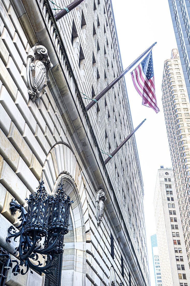 Low angle view of Federal Reserve Bank of New York building exterior and American flag, New York City, New York, USA