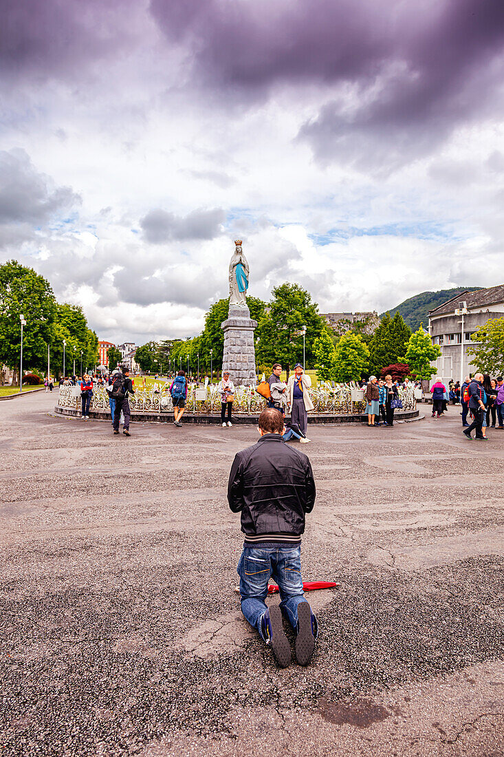 LOURDES - 15. JUNI 2019: Ein kniender Mann betet