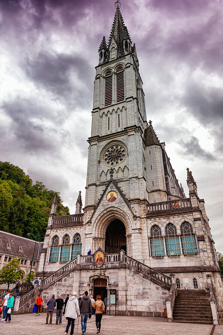 LOURDES - 15. JUNI 2019: Christliches Kreuz auf dem Hintergrund der Basilika Unserer Lieben Frau vom Rosenkranz in Lourdes,Frankreich