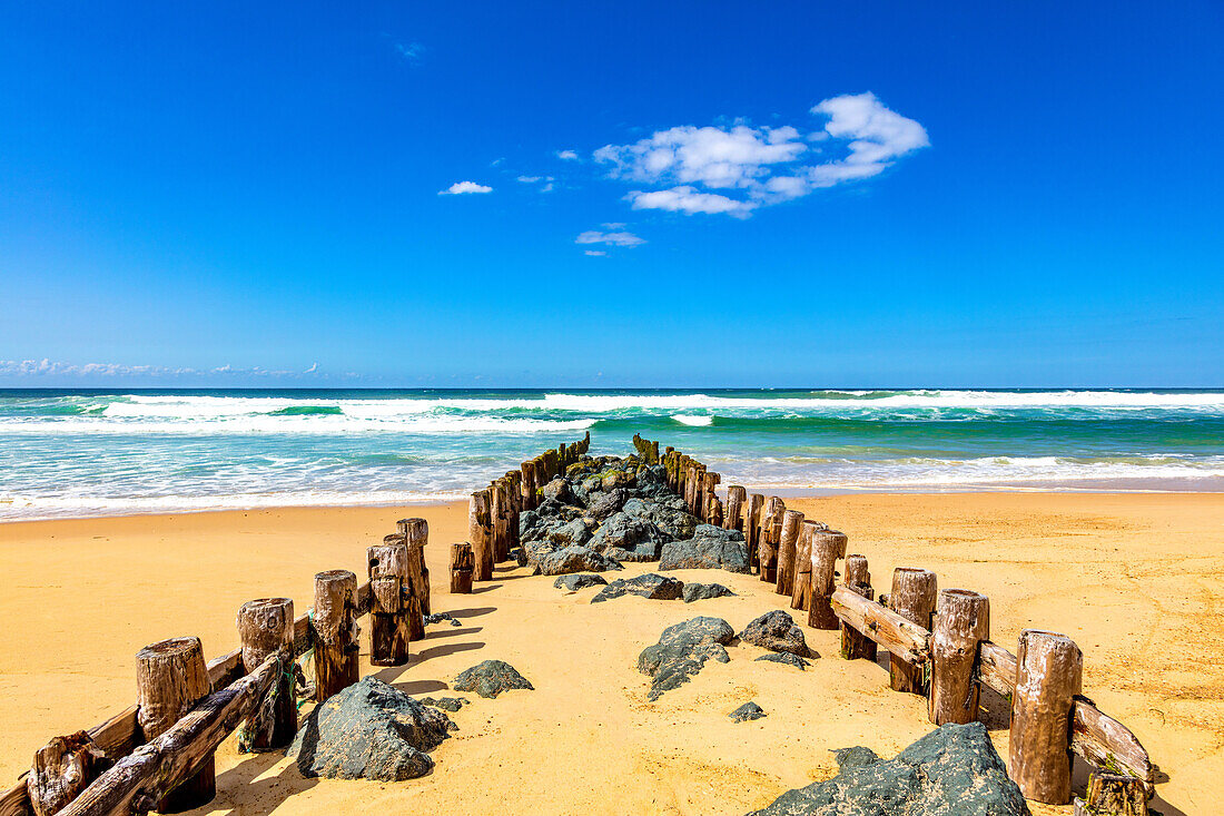 Blick auf Holzpfeiler und Steine am Strand von Seignosse,Landes,Frankreich