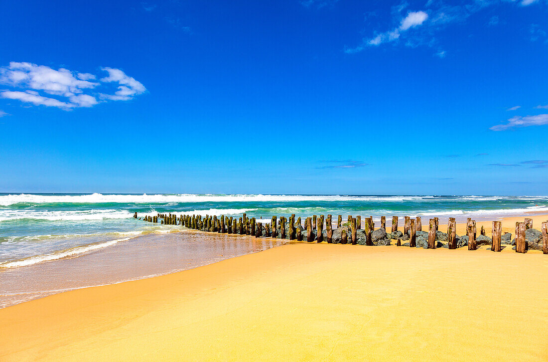 Blick auf Holzpfeiler und Steine am Strand von Seignosse,Landes,Frankreich