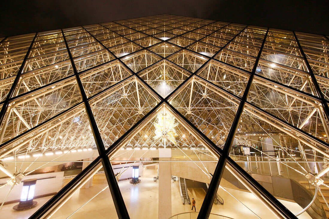 Paris. 1. Bezirk. Louvre-Museum bei Nacht. Die Pyramide (Architekt: Ieoh Ming Pei) nach der Schließung: ein Angestellter nimmt gerade die große Rolltreppe. Thronskulptur von Kohei Nawa, obligatorischer Kredit des Architekten: Ieoh Ming Pei