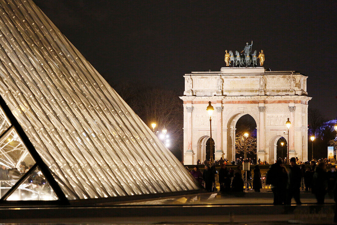 Paris. 1. Bezirk. Louvre-Museum bei Nacht. Im Vordergrund ist die Pyramide zu sehen (Architekt: Ieoh Ming Pei). Im Hintergrund der Triumphbogen des Louvre-Karussells. Obligatorische Angabe des Architekten: Ieoh Ming Pei