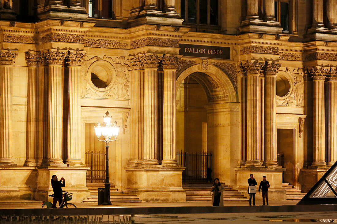 Paris. 1. Bezirk. Louvre-Museum bei Nacht. Touristen vor dem Denon-Pavillon.