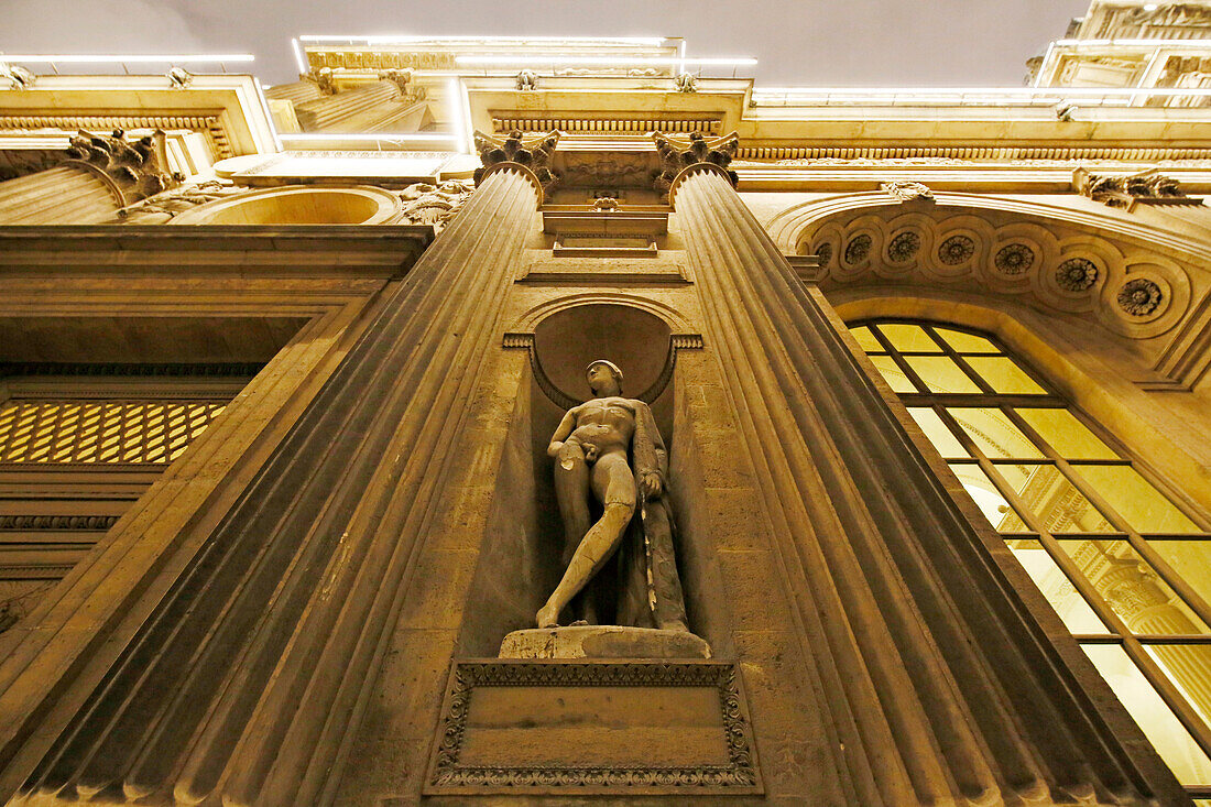 Paris. 1. Bezirk. Louvre-Museum bei Nacht. Quadratischer Innenhof. Fassade des Uhrenpavillons. Architektonisches Detail. Statue.