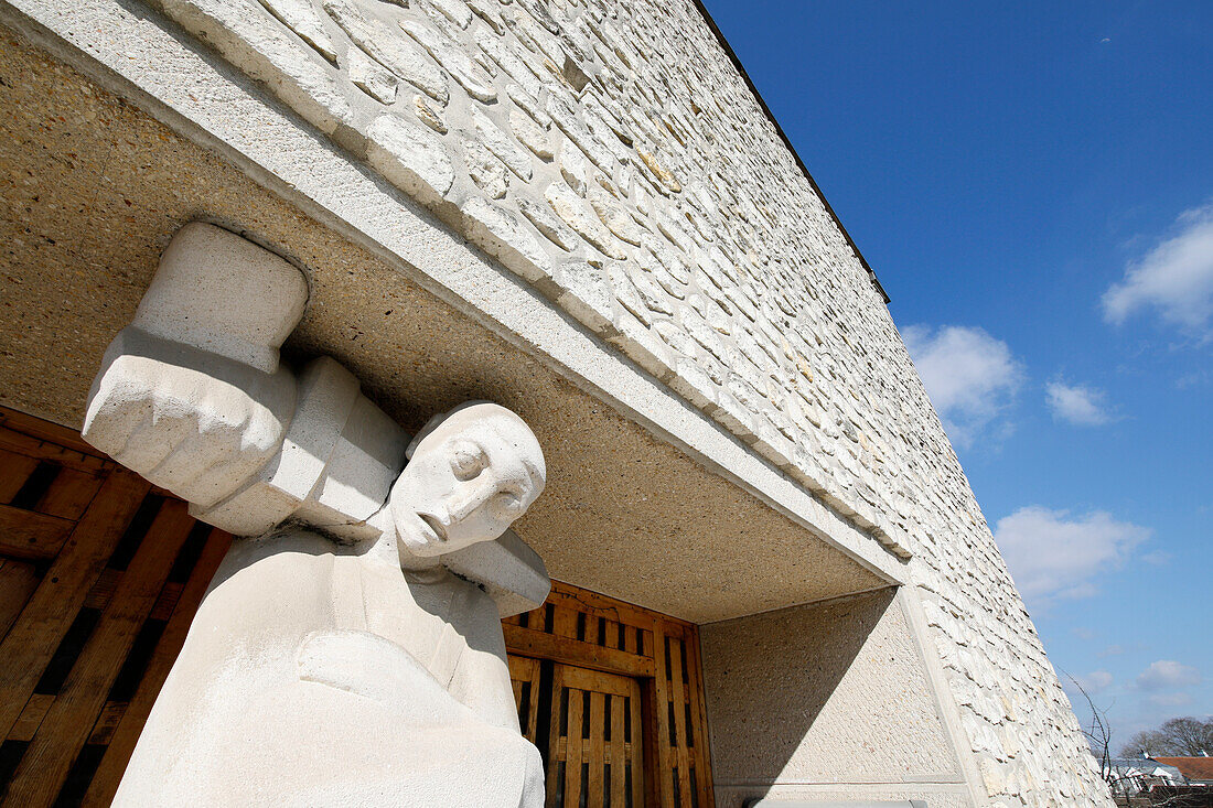 France. Seine et Marne. Tournan en Brie,medieval town center. View of the surprising Saint Denis church. Sculpture on the facade.