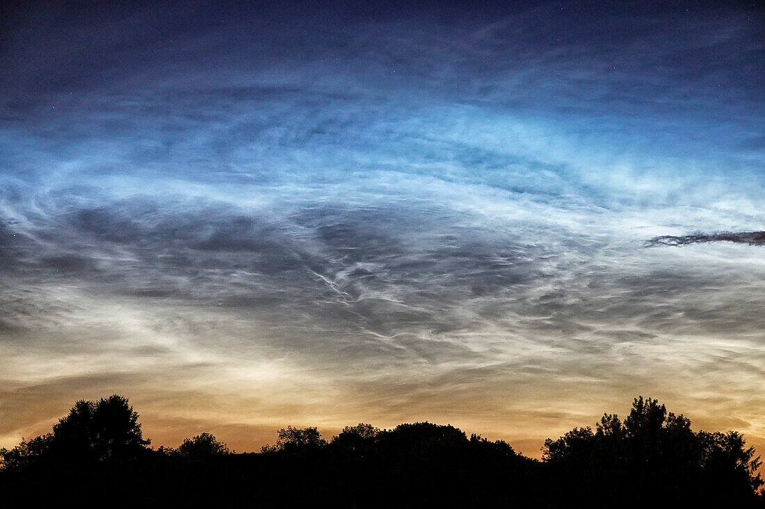 France. Seine et Marne. Coulommiers region. Noctilucent clouds visible in the sky at the beginning of the night on June 18,2021. These clouds are composed of ice and are located at the limit of space (about 80 km altitude).