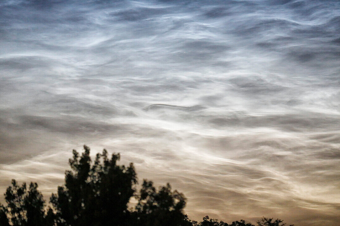 France. Seine et Marne. Coulommiers region. Noctilucent clouds visible in the sky at the beginning of the night on June 18,2021. These clouds are composed of ice and are located at the limit of space (about 80 km altitude).