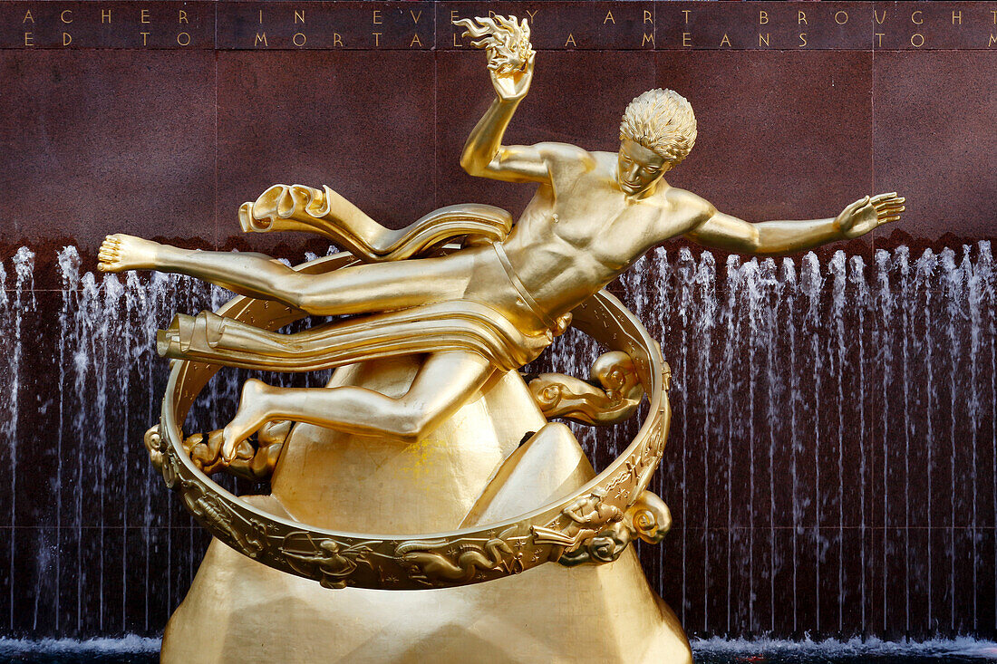 USA. New York City. Manhattan. Rockefeller Center im Winter. Statue Prometheus, von Paul Howard Manship (1885 - 1966). Eisbahn. Touristen beim Schlittschuhlaufen.