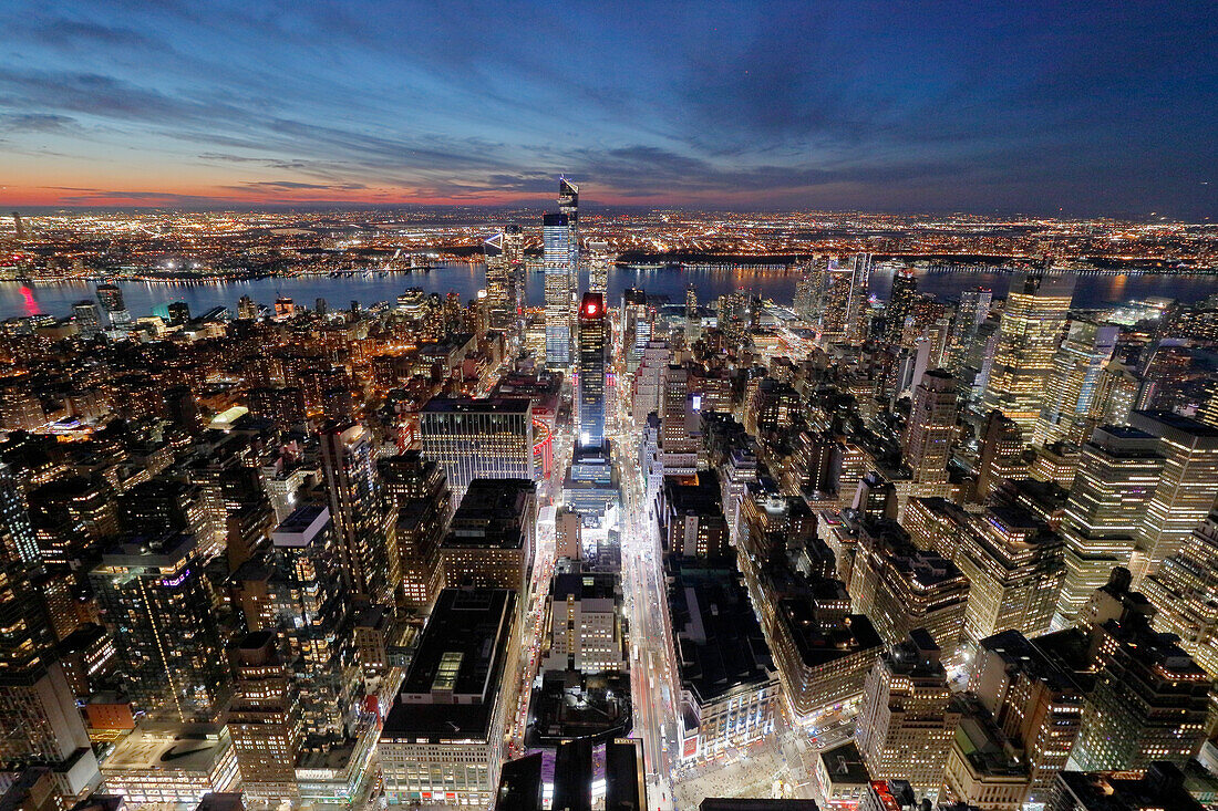 USA. New York City. Manhattan. Empire State Building. Blick von der Spitze des Gebäudes in der Abenddämmerung und bei Nacht. Blick auf das One World Trade Center und die Unterstadt. Der Hudson River ist rechts zu sehen.