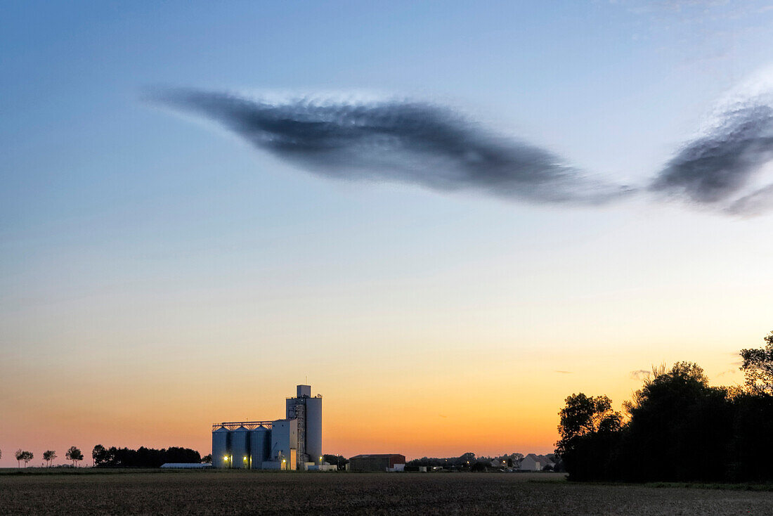 France. Seine et Marne. Coulommiers region. Summertime. Dusk. General view of the countryside. Spectacular grain silo and clouds.